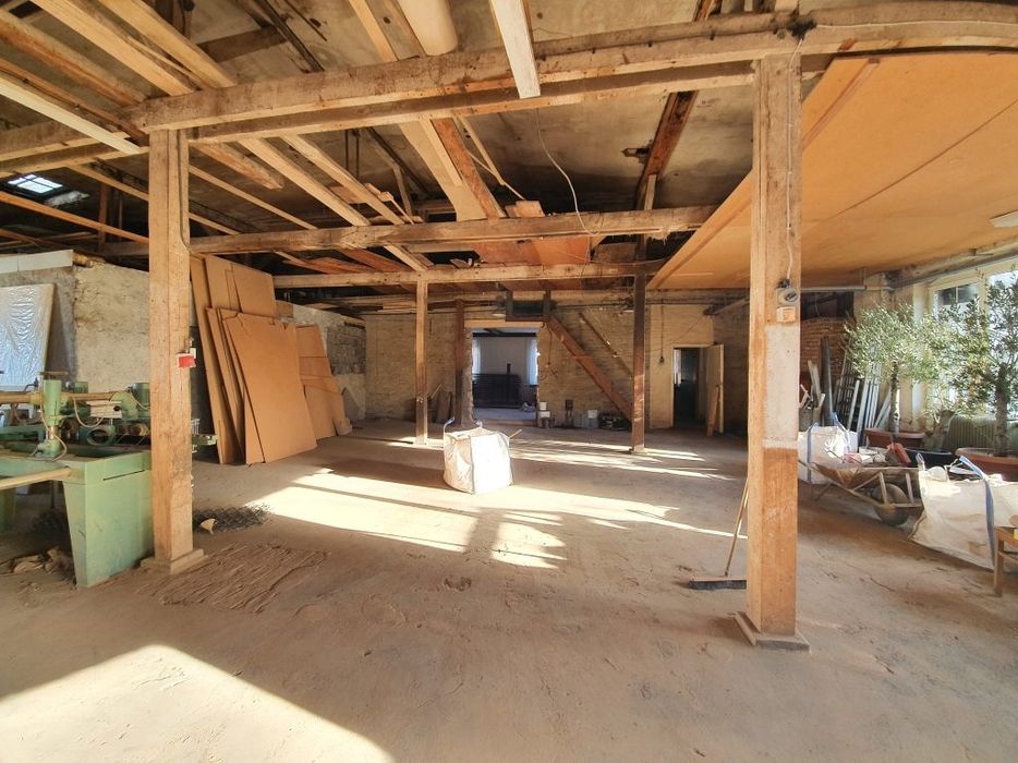 Innenansicht eines geräumigen Lagerraums mit Holzstützen und natürlichem Licht.