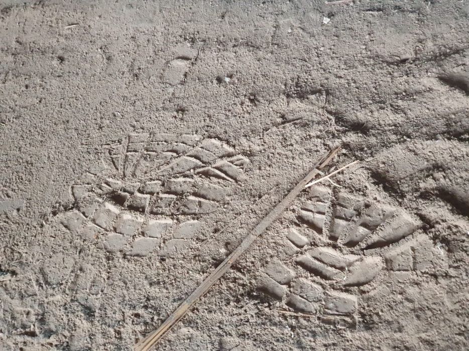 Zwei sichtbare Fußabdrücke im Sand