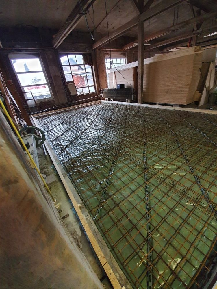Bauarbeiten an einer Bodenplatte mit Bewehrung im Innenraum