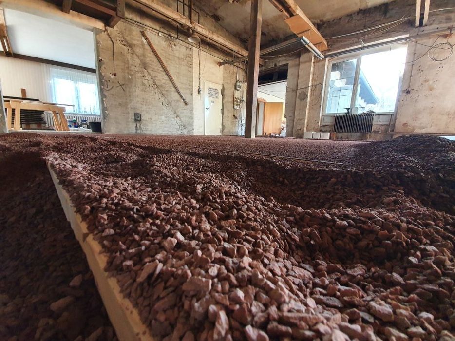 Innenansicht eines Raumes mit Kiesboden