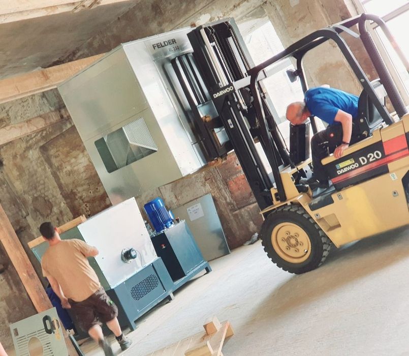 Arbeiter nutzt einen Gabelstapler in einer Fabrikumgebung.