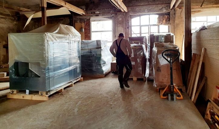 Ein Lagerraum mit verpackten Maschinen und Paletten.