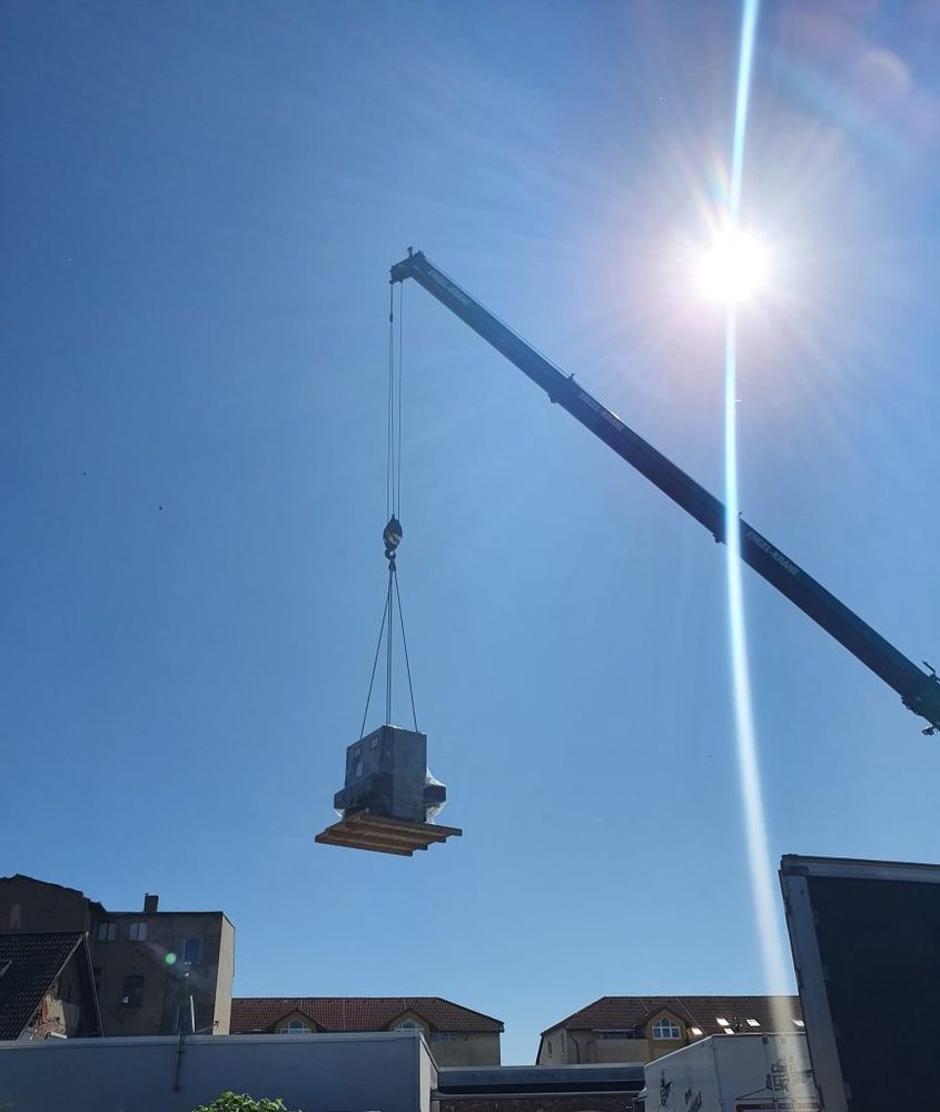 Ein Kran hebt eine Ladung in den Himmel.