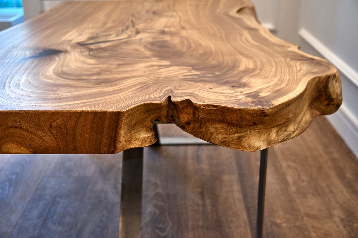 Detailaufnahme eines massiven Holztisches mit natürlicher Kante